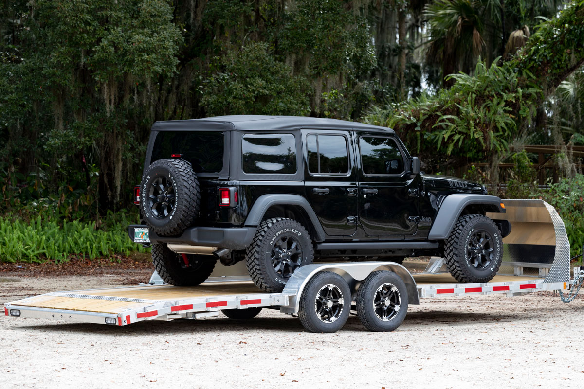 Black Jeep Loaded Onto Open Wood Deck Car Haulers