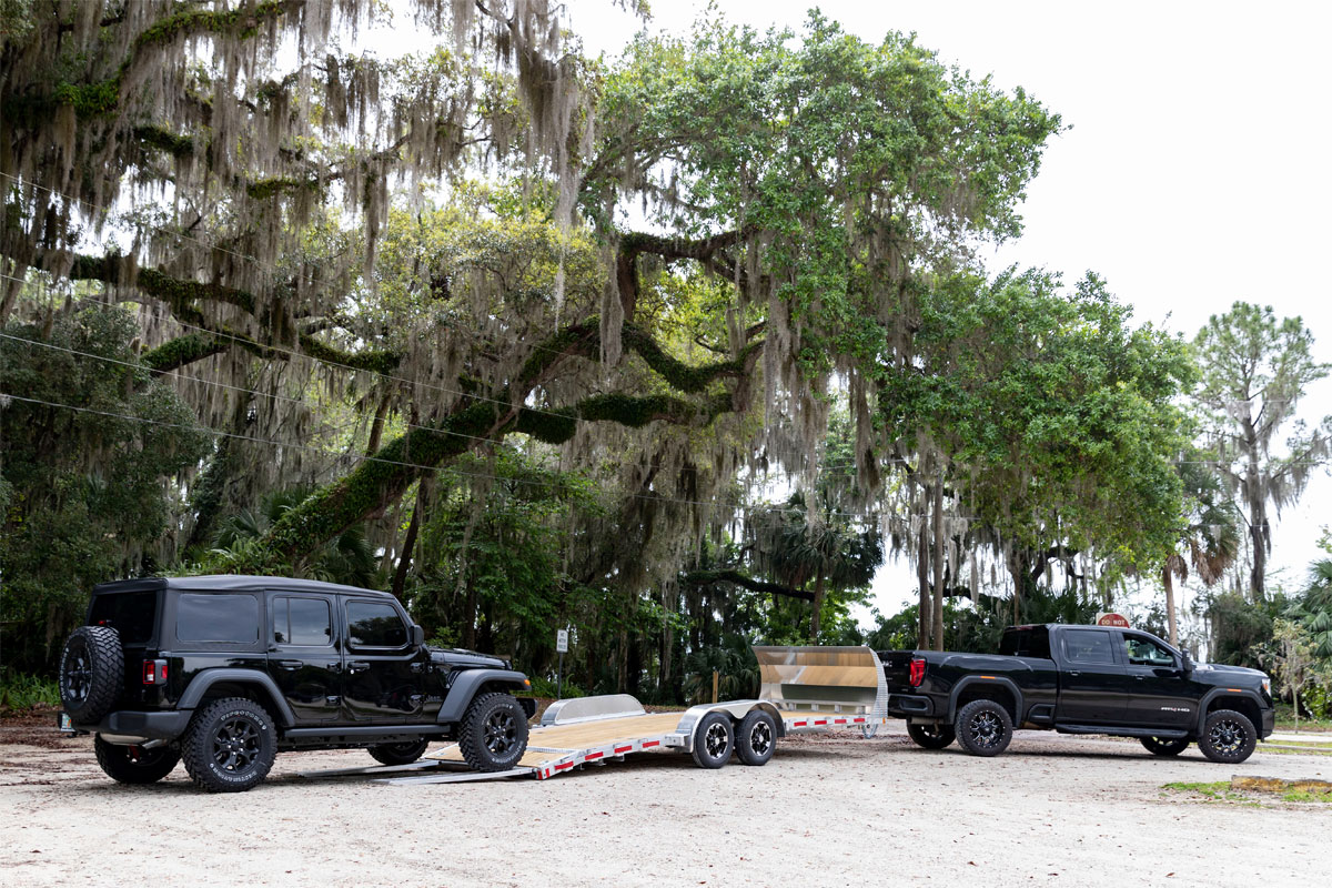 Black Jeep Loading Onto Open Wood Deck Car Haulers