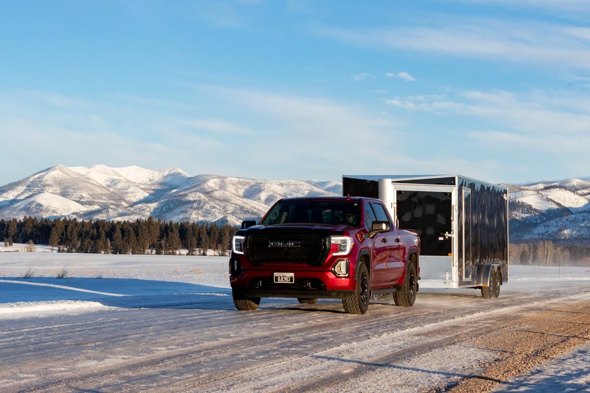 Enclosed Inline Black Snow Trailer Attached To A Red Truck