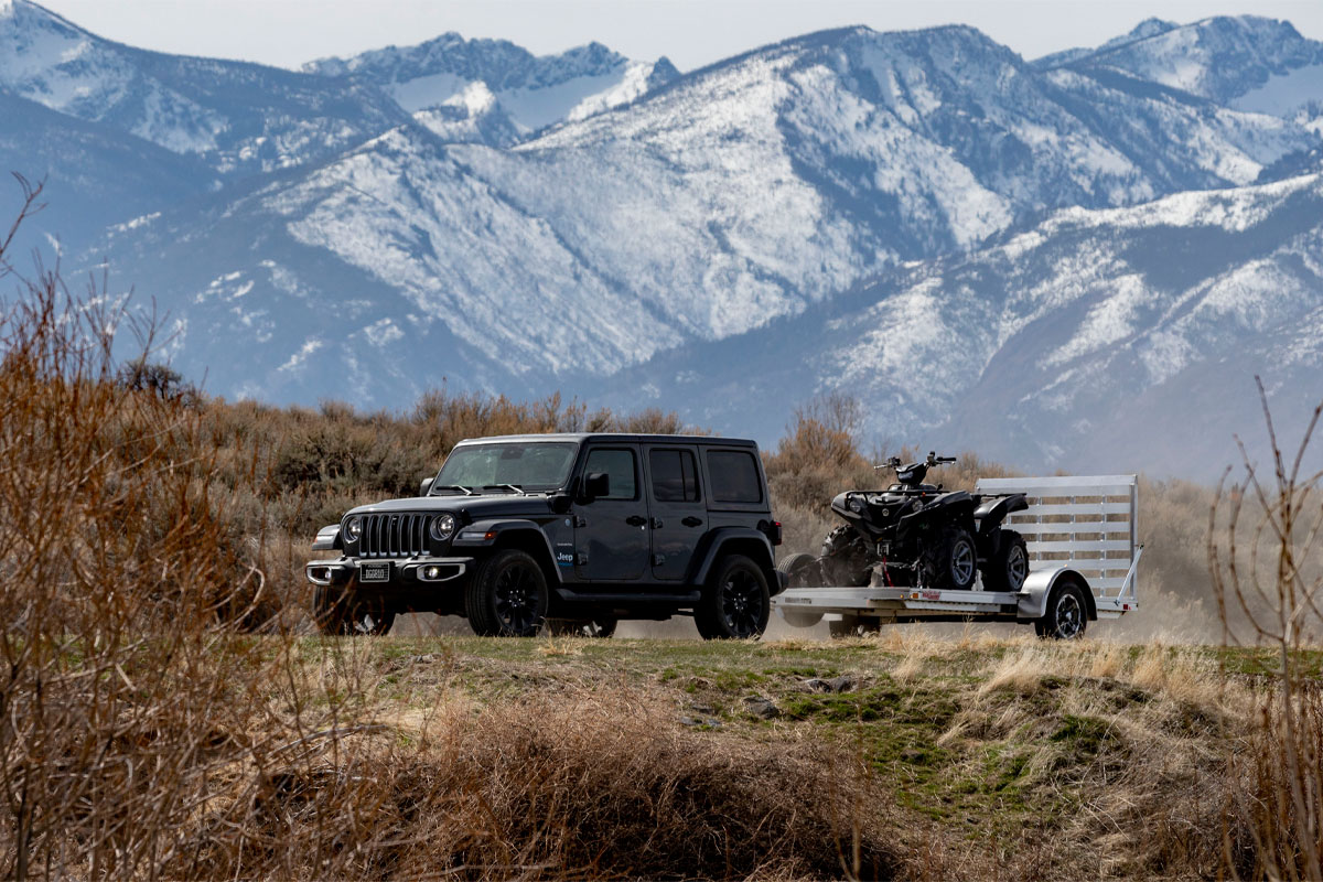 side-view-of-jeep-hauling-high-country-open-utility-ar-2.0-trailers-on-dirt-road