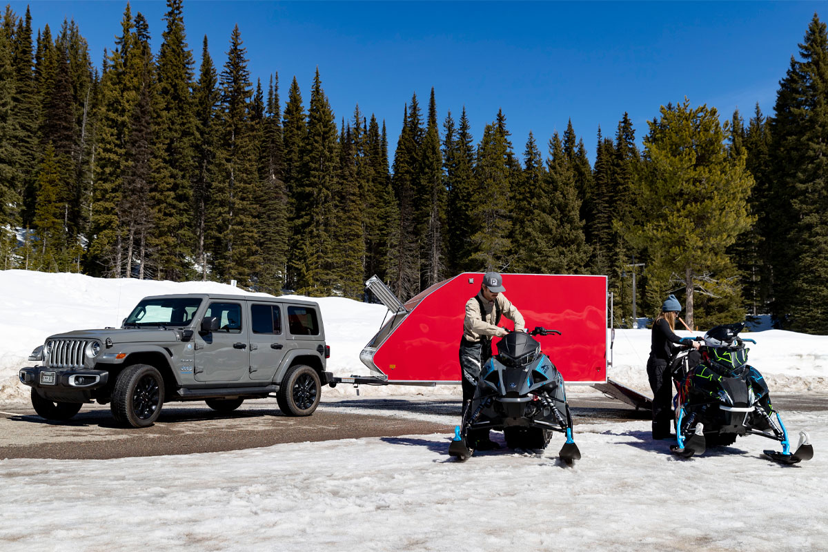 Snowmobiles Parked In Front Of High Country Enclosed Crossover Snow Trailer