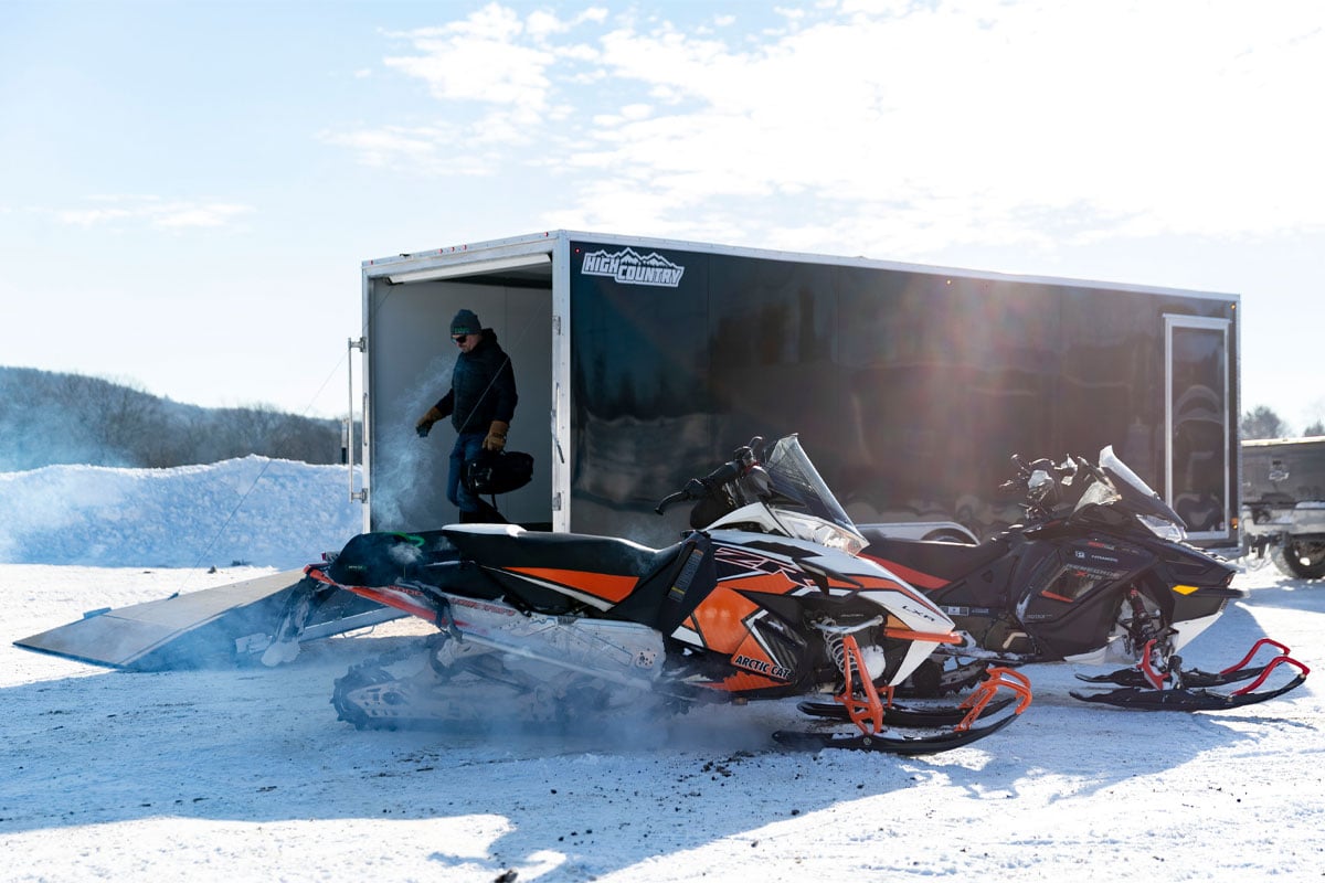 Snowmobiles Parked In front of Black High Country All Sport Snow Trailer